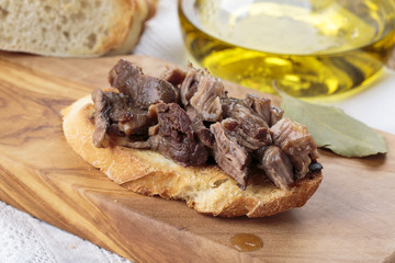 Peposo served over bruschetta.