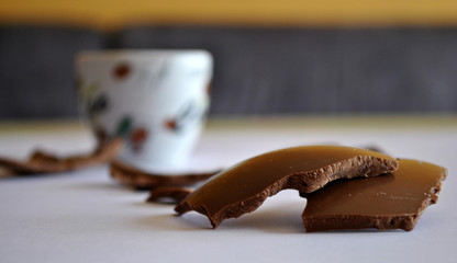 Cracked Eggs chocolate and cup of coffee. Blurred background.