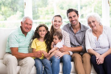 Portrait of smiling family with baby while sitting on sofa