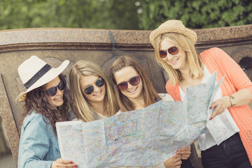 Vier junge Touristinnen mit Stadtplan