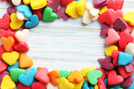 Colorful candy hearts on a blue wooden table