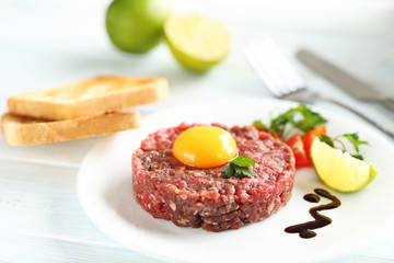 Beef tartare with egg yolk on a blue wooden table