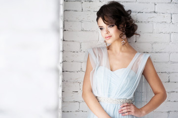 Obraz premium Portrait of a beautiful girl near white wall