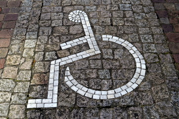 Rollstuhlpiktogramm auf Pflasterboden