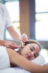 Obraz na płótnie Canvas Woman receiving ear candle treatment
