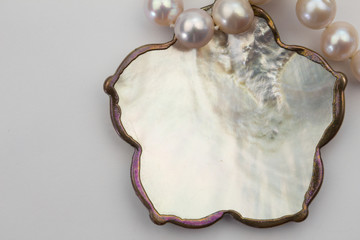 Pearl necklace and mother of pearl pendant isolated on white
