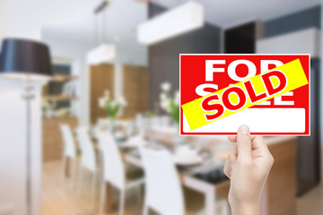 hand holding sold house sign