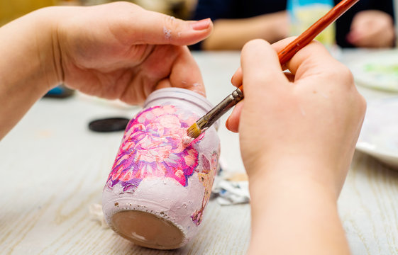 decoupage bottle. Professional painter paints a souvenir