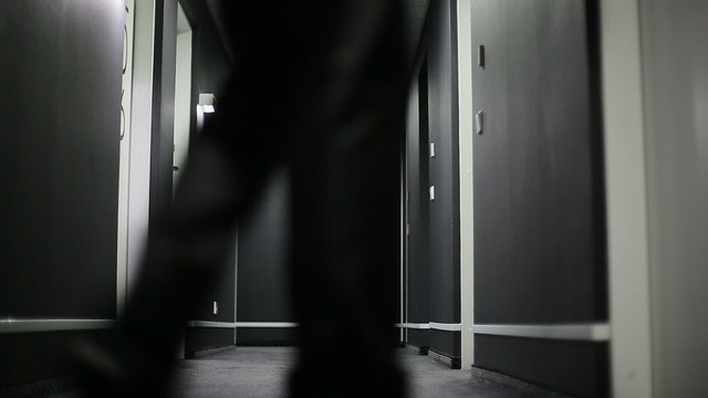 Businessman with a suitcase in a corridor of hotel