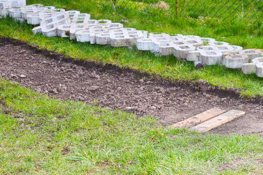 Verlegearbeiten von Betonsteinen, Rasengittersteine als Zufahrtsweg zur Garage, Gartenweg, Weg und Zufahrt