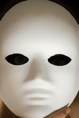 Person behind a white mask closeup