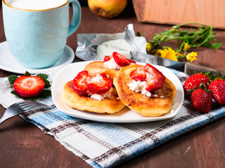 Breakfast with cottage cheese pancakes with cream cheese and strawberries and a cup of milk