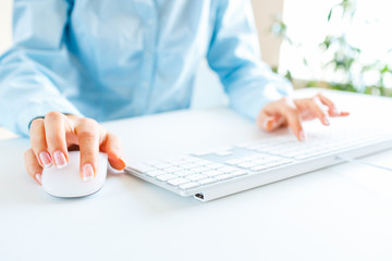 Woman office worker typing on the keyboard