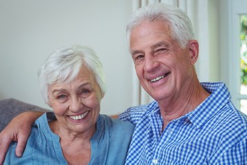 Portrait of smiling retired couple with arm around 