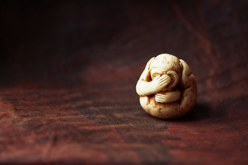 Three wise monkeys or Three Mystic Apes sacred ancient icon, brown background 