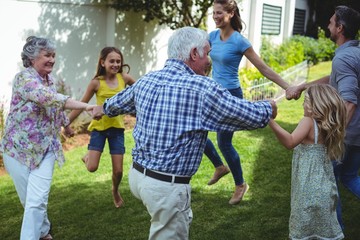 Multi-generation family playing in back yard