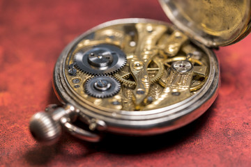 Uhrwerk einer Taschenuhr aus dem 19. Jahrhundert mit künstlerischer Unschärfe und rotem Grund
