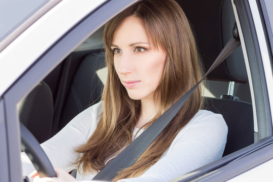 Young confident car driver woman steering wheel