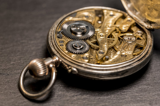 Uhrwerk einer Taschenuhr aus dem 19. Jahrhundert mit künstlerischer Unschärfe und schwarzem Grund