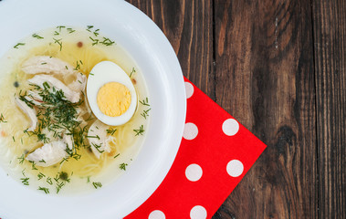 Chicken soup with noodles, carrots, eggs. 