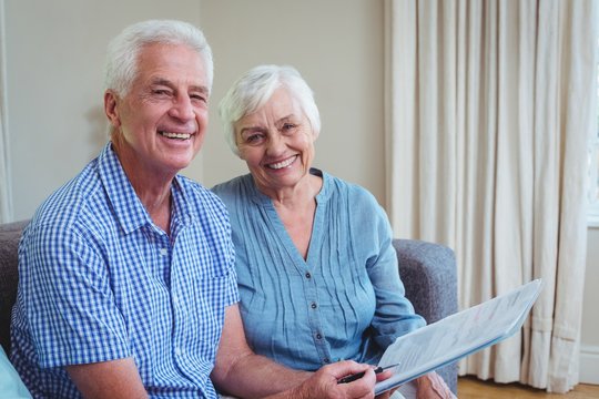 Portrait Of Happy Senior Couple With Bills 