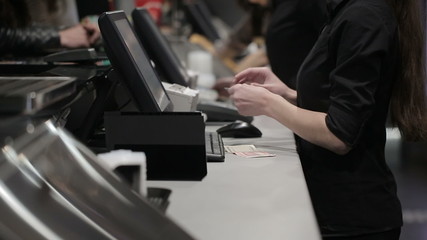 Cash register in the shop. Employees and buyers - Powered by Adobe