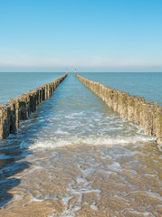 Between the two rows of poles of the breakwater