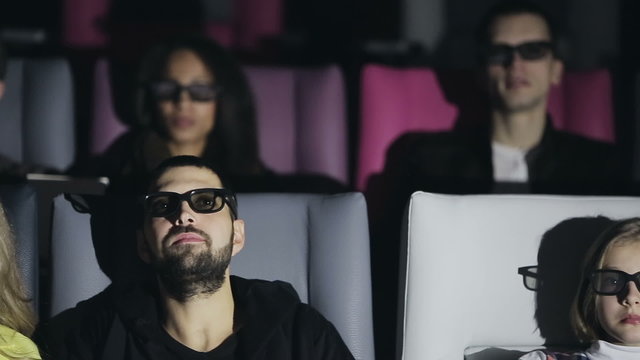 Group of people in 3D glasses watching a movie at cinema