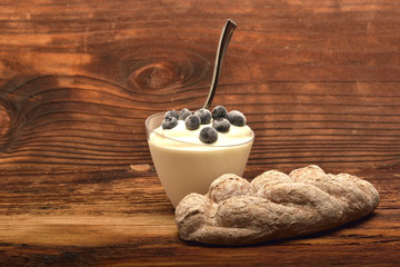 Yogurt in a cup with cranberries and bread