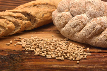 Bread with grain on wooden background