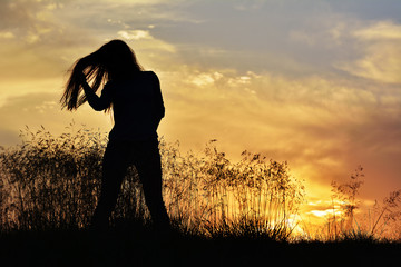 beautiful woman on field at sunset, summer evening