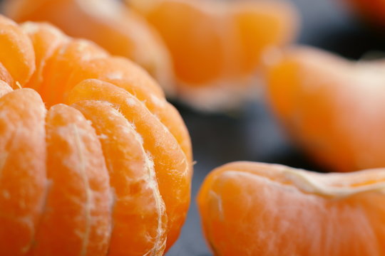 Cantels of mandarins with peels on a dark table. Macro