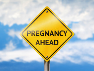 Pregnancy ahead road sign. Blue sky and yellow traffic sign