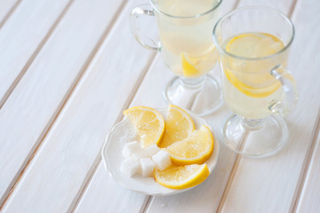 Hot ginger lemonade with sliced lemon and sugar cubes