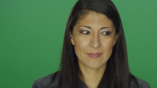 Ethnic woman looking shy and nervous, on a green screen studio background
