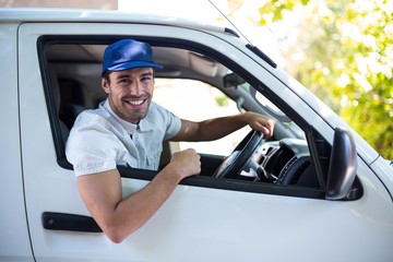 Smiling delivery man sitting in van