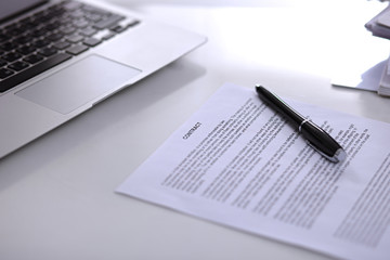 .Office workplace with a laptop and contract document on the light reflecting table