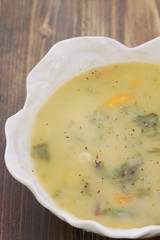 vegetable soup in white bowl on brown wooden background