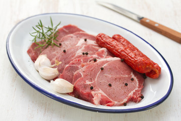 pork with black pepper, smoked sausages and garlic on dish and knife