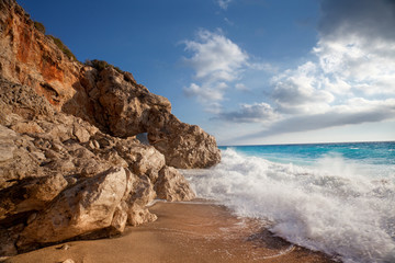 Fototapeta na wymiar Beautiful beach landscape. Wave splashing on shore rocks.