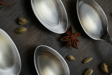 Olive oil in the spoons on wooden background. Close up