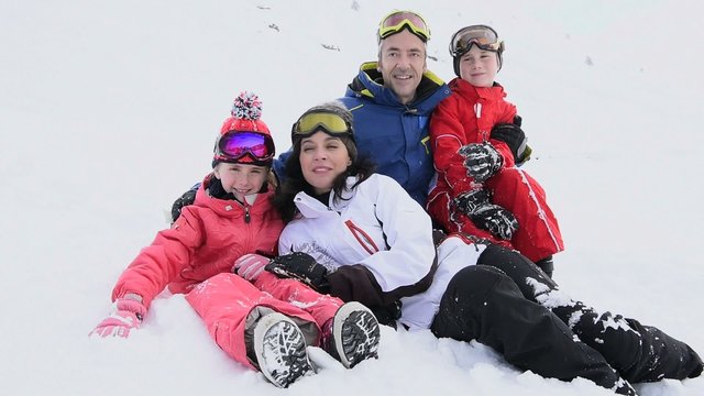 Portrait of family having fun laid in the snow