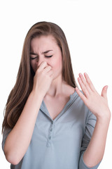Young woman closes her nose because of the smell