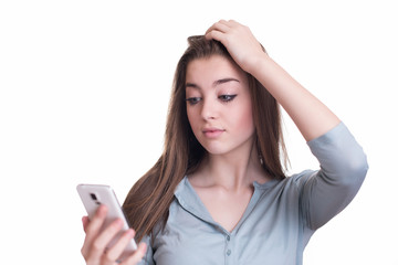 Anxious young girl looking at phone seeing bad news
