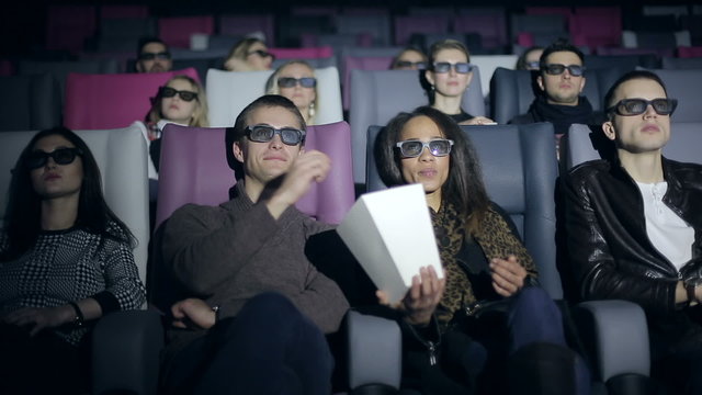 Group of people in 3D glasses watching a movie at cinema