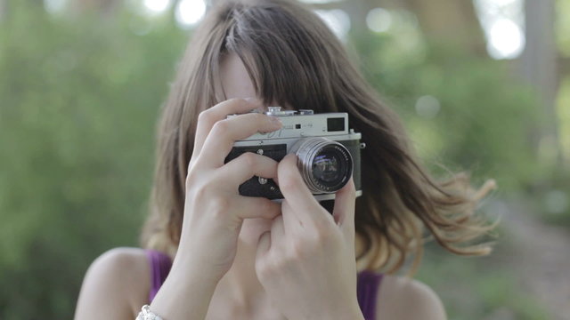 Girl taking pictures with vintage camera