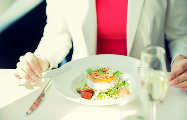 close up of woman eating salad at restaurant