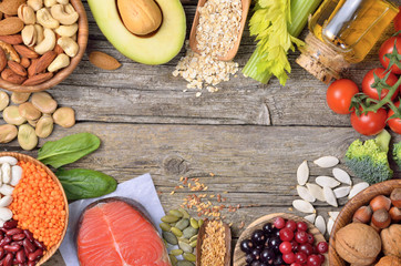 Healthy eating background. Different vegetables,nuts,oils and beeries on wooden table. Copyspace background. Top view.