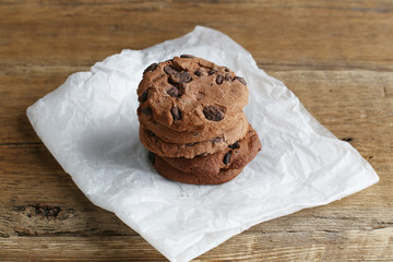 Cookies with chocolate chip on parchment paper napkin on wooden background