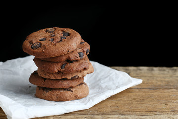 Cookies with chocolate chip on parchment paper napkin on wooden